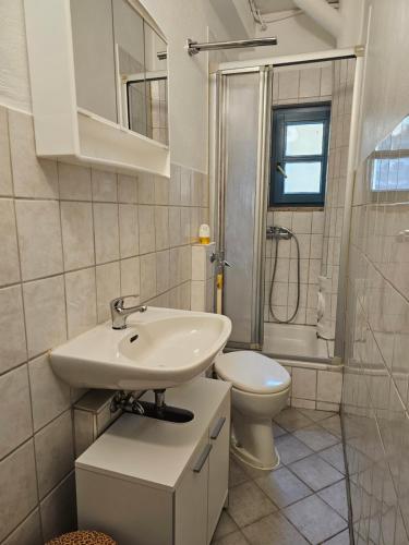 a white bathroom with a sink and a toilet at B&R Ganze Apartment Süd Nürnberg in Nürnberg