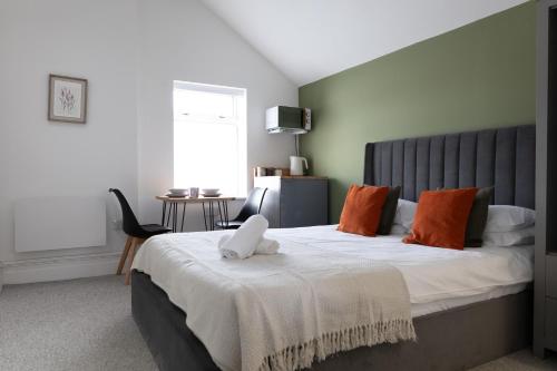 卡地夫的住宿－Bay City Studio Apartments，一间卧室配有一张带橙色枕头的大床