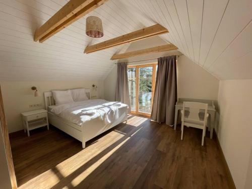 1 dormitorio con cama blanca y ventana en Luxury Villa Pitraga Viļņi en Pitragutsiyeme