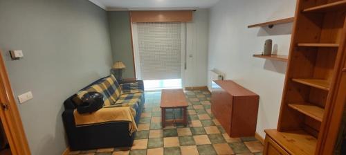 - un salon avec un canapé et une table dans l'établissement Apartamento SIRO Compostela, à Saint-Jacques-de-Compostelle