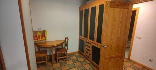 Cette chambre dispose d'une table et d'une porte en bois. dans l'établissement Apartamento SIRO Compostela, à Saint-Jacques-de-Compostelle