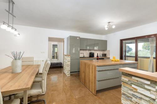 a kitchen with white walls and a wooden table at Villa Miromar APP in Pula