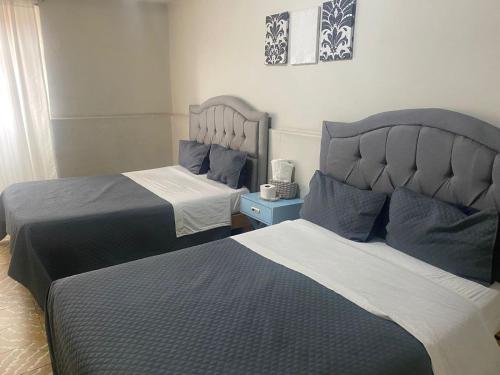 two beds sitting next to each other in a bedroom at Hotel El Rincón de Jesusita in Durango