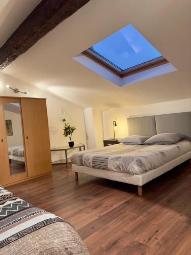 a bedroom with two beds and a skylight at Petit nid cosy au cœur du Puy 1 à 5 personnes in Le Puy en Velay