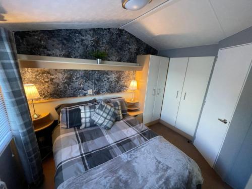 sypialnia z łóżkiem i poduszkami w obiekcie Golden Palm Resort - Carnival - Coastal Caravan Breaks w mieście Chapel St Leonards