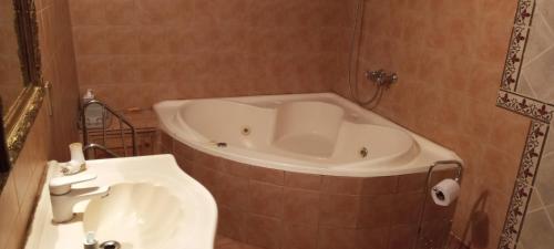 a bathroom with a tub and a white sink at La casa de Angelita in Trelew