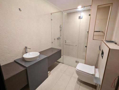 een badkamer met een toilet, een wastafel en een douche bij DHA Phase 4 Gold Crest Mall One Bedroom Serviced Apartment in Lahore