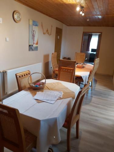 a dining room with two tables and chairs at Panoráma Apartmanház in Abaújszántó