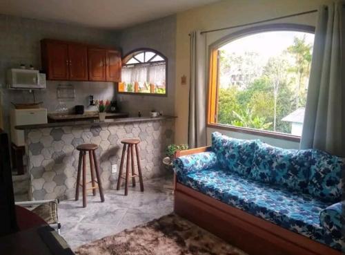 ein Wohnzimmer mit einem Sofa und einem Fenster in der Unterkunft Aconchego no bairro mais charmoso da serra. in Nova Friburgo