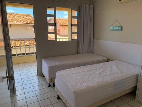 Duas camas num quarto com vista para uma varanda em Casa com 4 quartos em condomínio em Maria Farinha em Paulista