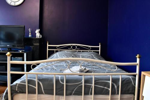 1 dormitorio con 1 cama con pared azul en La Domus Lemaitre 5- Parking - TV - Wifi 