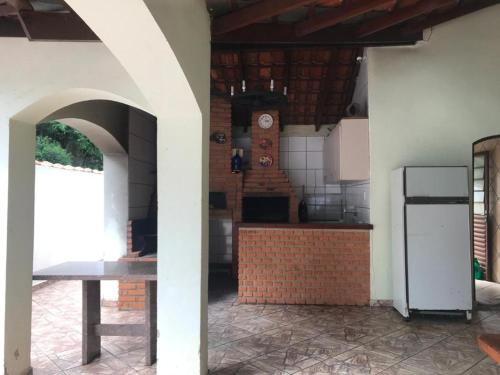 a kitchen with a table and a clock on the wall at Casa de Campo I Cond Ninho Verde II in Pardinho