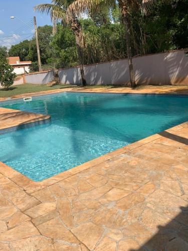 a swimming pool with blue water in a backyard at Casa de Campo I Cond Ninho Verde II in Pardinho