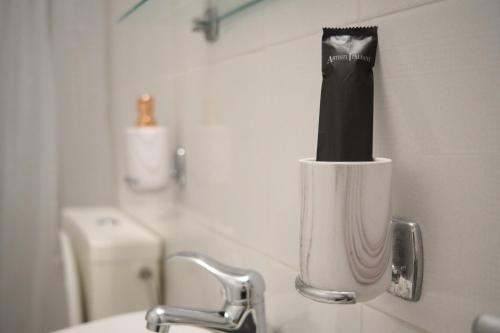 cepillo de dientes en un cepillo de dientes en el lavabo del baño en Georgia's Comfort City Center apartment, en Tripolis