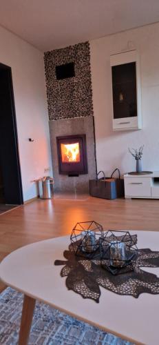 a living room with a fireplace and a table at Katrins Ferienwohnung in Hammelburg