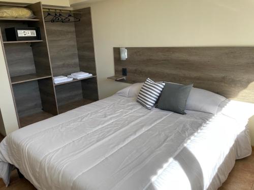 a bedroom with a large white bed with pillows at Apart Milo in San Carlos de Bariloche