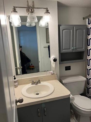 a bathroom with a sink and a toilet and a mirror at Direct ocean front view 1 bedroom Open Pool Ocean J in Daytona Beach