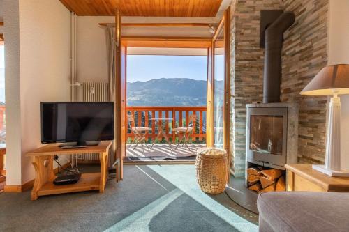 un salon avec une télévision et une cheminée dans l'établissement Carlines E19, à Méribel