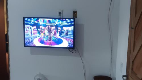 TV de pantalla plana colgada en la pared en aconchego, en Pipa