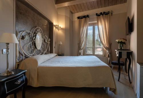 Hotel Residenza la Ceramica في فابريانو: غرفة نوم بسرير كبير ونافذة
