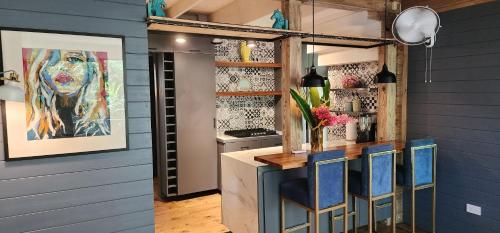 a kitchen with blue walls and a counter with blue stools at Boutique Hotel y Spa Tangara Azul in Ojochal