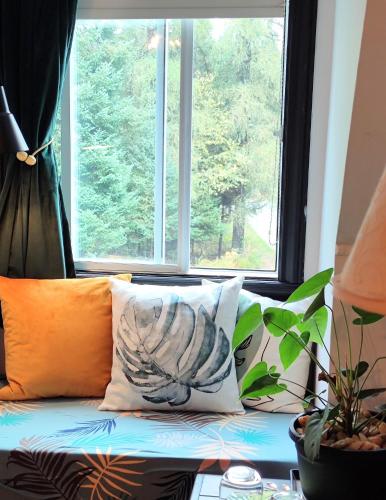 a couch with pillows in front of a window at La Tremblante in Mont-Tremblant