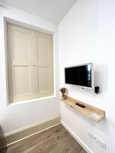 une pièce avec une télévision à écran plat sur un mur dans l'établissement Le Nacre 14 - Bourg-de-Péage, à Bourg-de-Péage