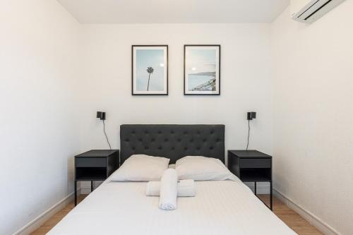 une chambre avec un lit blanc avec deux tables de nuit dans l'établissement 68 ARSON - Appt 2 pièces dernier étage - Terrasse - Parking, à Nice