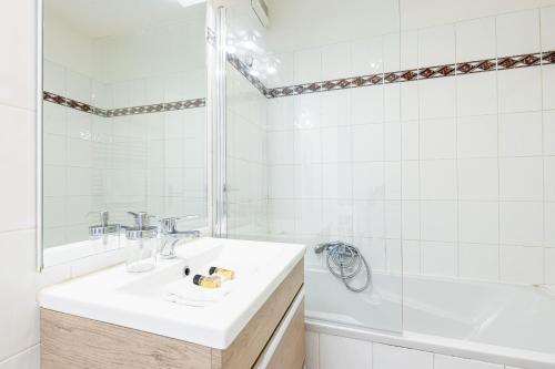 une salle de bain blanche avec un lavabo et une douche dans l'établissement 68 ARSON - Appt 2 pièces dernier étage - Terrasse - Parking, à Nice