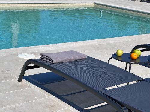 a table and two chairs next to a swimming pool at Topos luxury stay Heraion in Loutraki