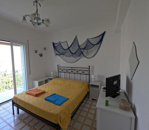 a bedroom with a bed and a television in it at Andrea's Home in Marina di Modica