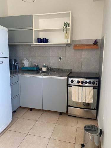 a small kitchen with a stove and a sink at Departamento Liniers in Resistencia