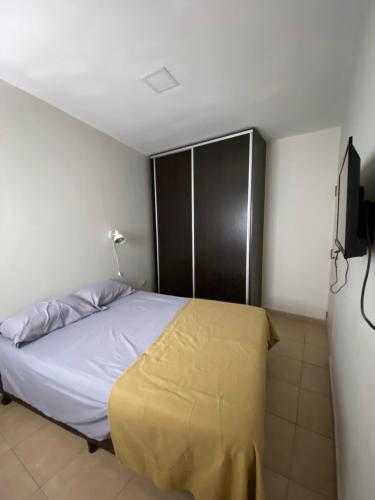 a bedroom with a bed with a yellow blanket on it at Departamento Liniers in Resistencia