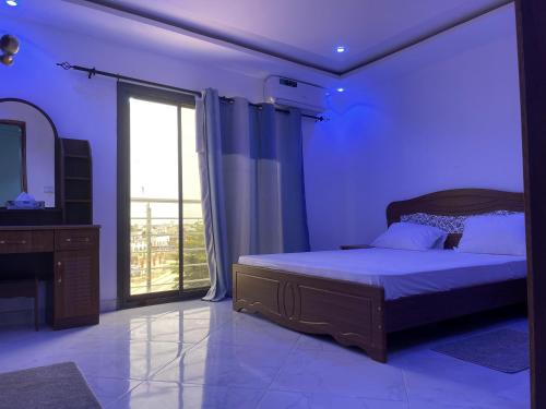 - une chambre avec un grand lit et un miroir dans l'établissement residence cheikh mahy cisse, à Kaolack