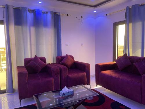 residence cheikh mahy cisse في Kaolack: غرفة معيشة مع كرسيين وطاولة قهوة