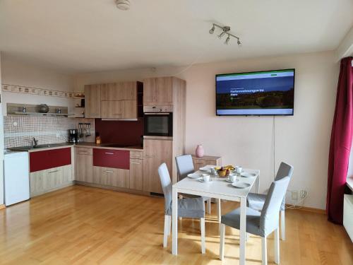 a kitchen and dining room with a white table and chairs at Apartment Bergzauber - traumhafter Ausblick & Pool in Braunlage