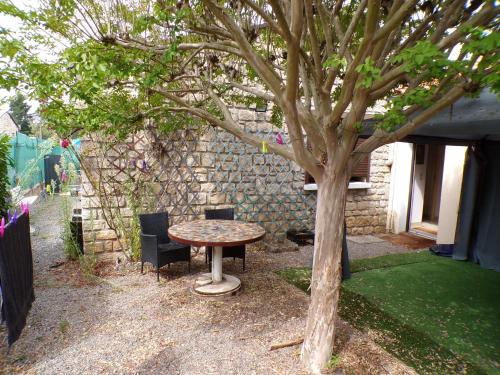 una mesa y sillas sentadas junto a un árbol en Suite Royale dans Vôtre maisonnette indépendante avec terrasse Privée !, en Montmorillon