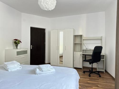 a bedroom with a bed and a desk and a chair at XOX Comfort Giurgiului in Bucharest
