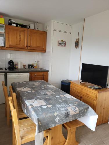 une cuisine avec une table recouverte d'une nappe dans l'établissement Appartement Superdevoluy, à Saint-Étienne-en-Dévoluy