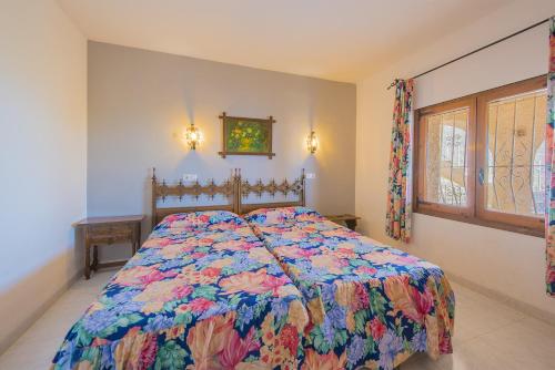 a bedroom with a bed with a colorful quilt at Casa Maryvilla 46 in La Canuta