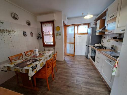 a kitchen with a table and chairs and a kitchen with white cabinets at Appartamento Giotto - Free Parking in Livorno