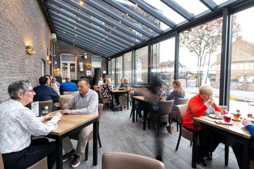 un gruppo di persone seduti ai tavoli in un ristorante di Brasserie Sint Pieter a Rekem