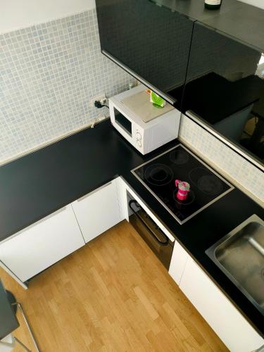 a small kitchen with a stove and a microwave at B&B Vimo - Appartamento con terrazzo privato Milano San Raffaele - Vimodrone in Vimodrone