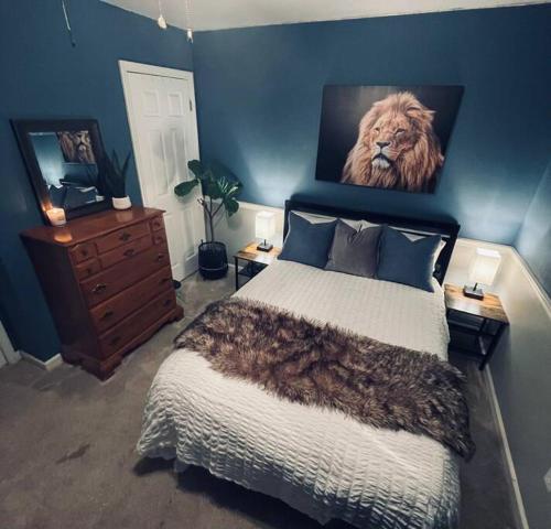 Schlafzimmer mit einem Bett mit Löwenbild an der Wand in der Unterkunft *Candlewicke Vista Nashville Retreat* Pets Welcome! in Spring Hill