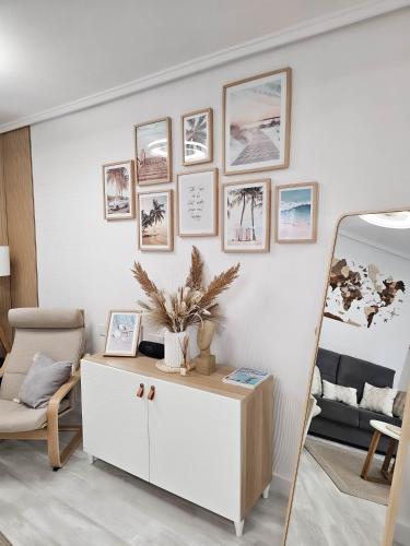a living room with a white cabinet and pictures on the wall at Casa Dorsya - near the beach, Torrevieja, Spain in Torrevieja