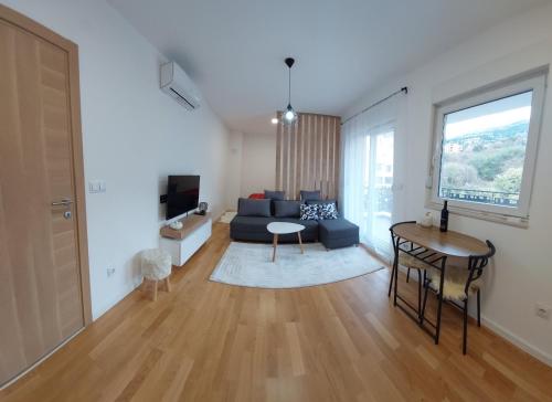 ein Wohnzimmer mit einem Sofa und einem Tisch in der Unterkunft Apartman ENEM in Mostar