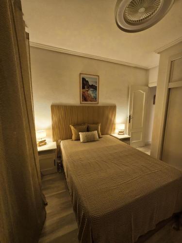 a bedroom with a large bed with two night stands at Casa Dorsya - near the beach, Torrevieja, Spain in Torrevieja