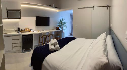 1 Schlafzimmer mit einem weißen Bett und einer Küche in der Unterkunft Nari Guest Room in Fernando de Noronha