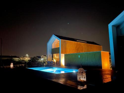 un edificio con piscina por la noche en Modern barn house in countryside, en Murtosa