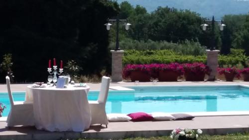 a table and chairs next to a swimming pool at Grotta Biscia in Genazzano